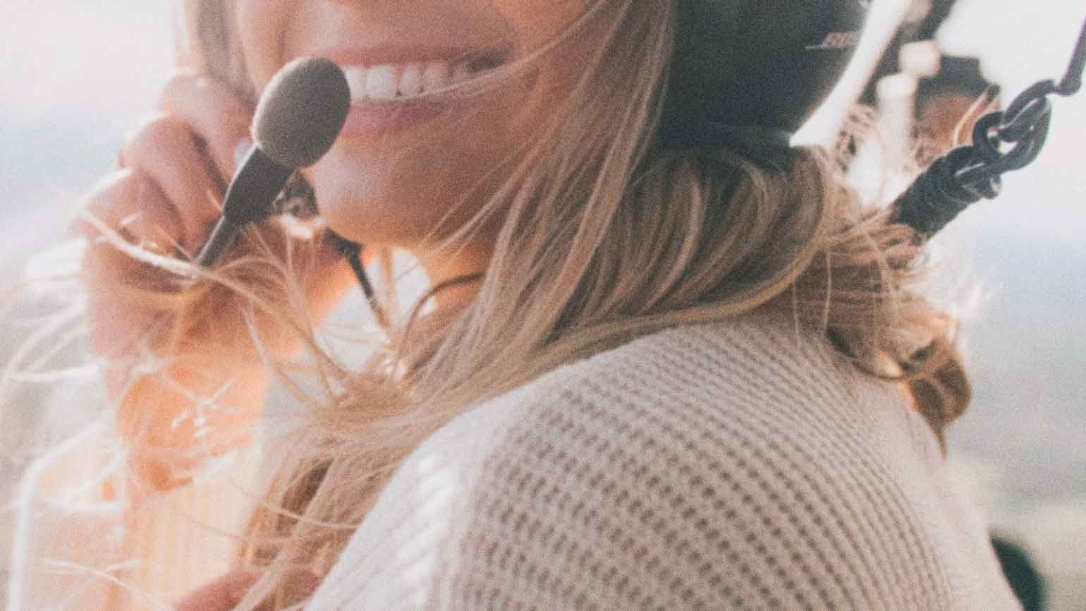 Woman achieves goal of flying in a helicopter with her headset on.